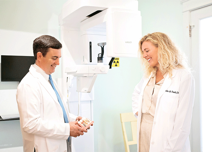 Dr. Green and Dr. Roach talking in front of an X-ray machine at Fairhope Dental Associates in Fairhope, AL.