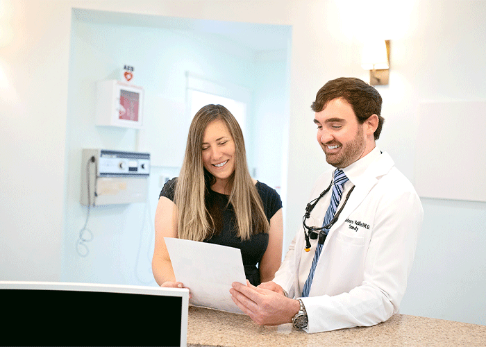 Dr. Sandy Vallee discussing paperwork with a patient at Fairhope Dental Associates in Fairhope, AL.